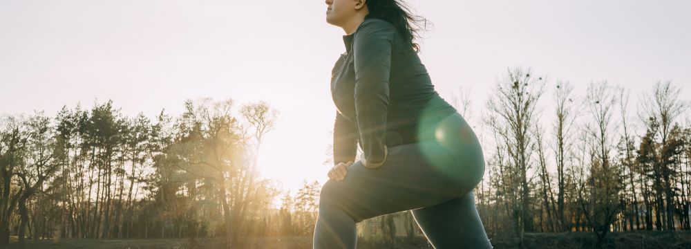 Woman exercising outdoors, lunging on one leg